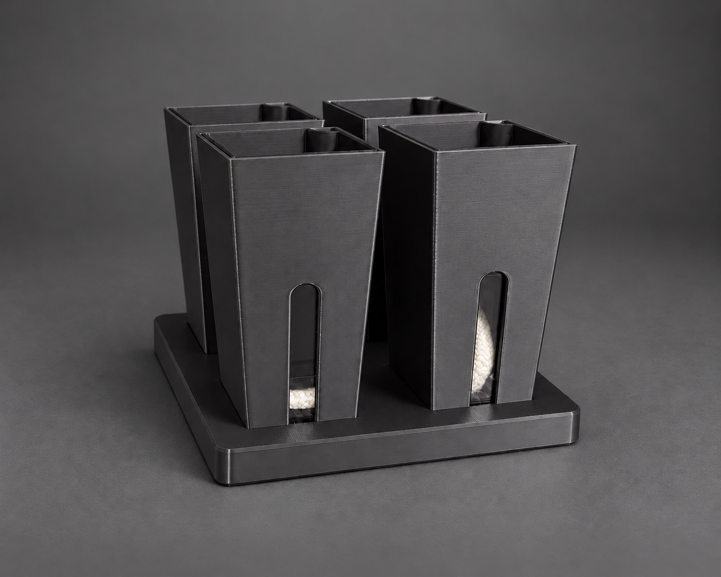 Four black small self-watering cups in their matching base