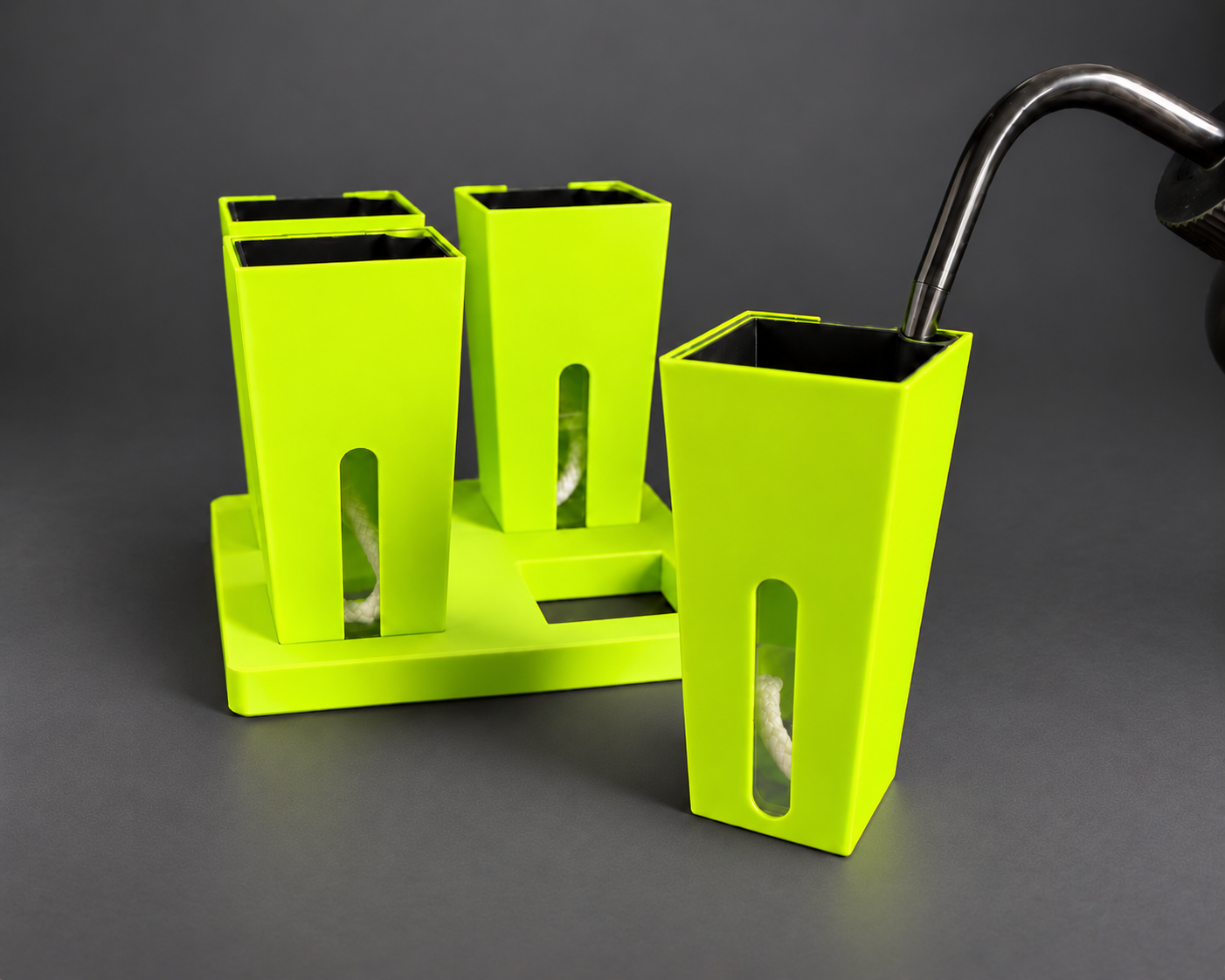 Neon Green small self-watering cups with one cup removed from the base and the watering nozzle seated in the inner pot corner opening